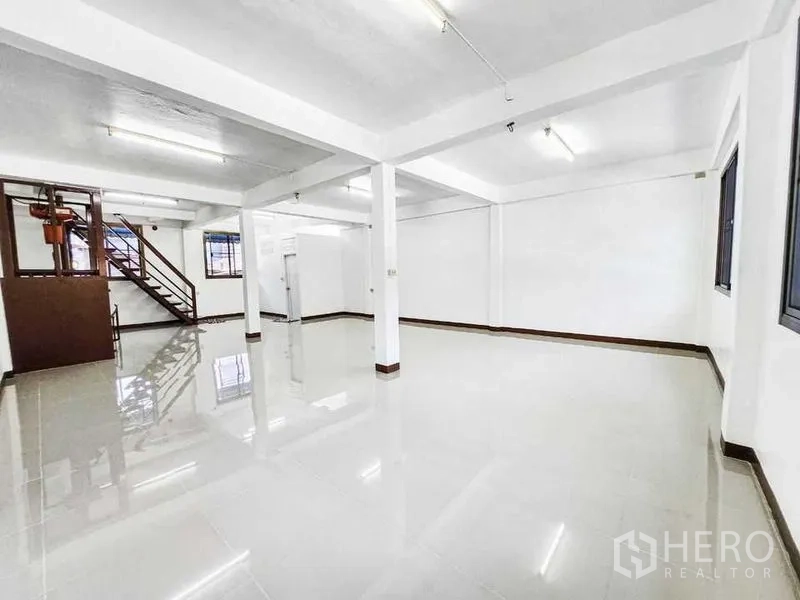Home Office for rent in Khlong Toei, Bangkok - Bright open-plan floor with glossy tiles, columns, windows and a side staircase.