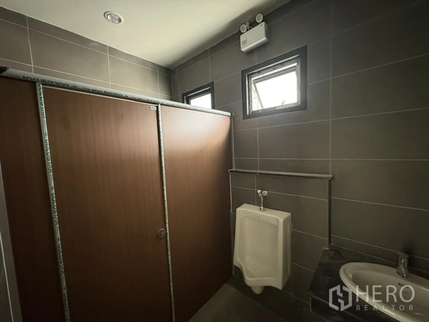 โรงงาน for rent in Bang Pakong, Chachoengsao - ห้องน้ำพร้อมโถปัสสาวะ ฉากกั้น และช่องลมระบายอากาศ.