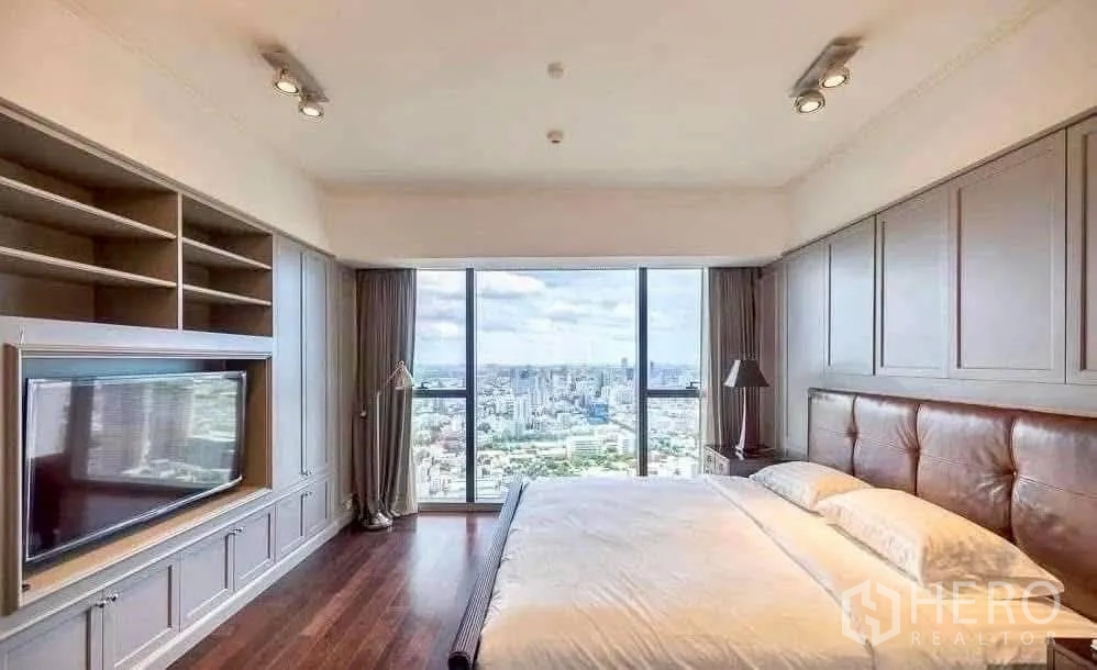 Condominium for rent in Sathon, Bangkok - Master bedroom with built-in media wall and sweeping skyline view through floor-to-ceiling windows.