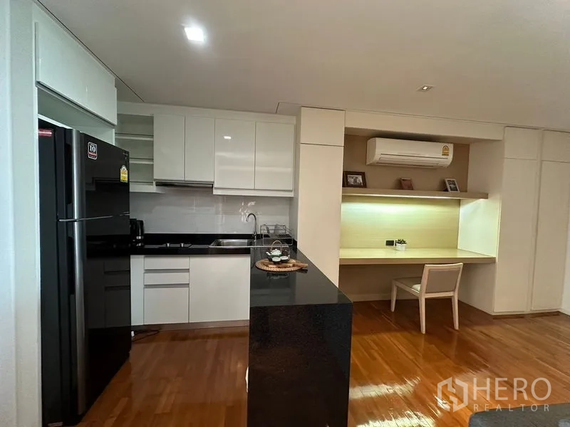 Apartment for rent in Khlong Toei, Bangkok - Open kitchen with island and adjacent work station on hardwood floors.