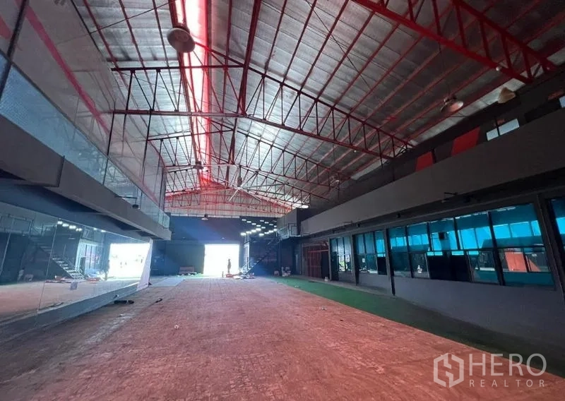 Showroom for rent in Mueang Samut Prakan, Samut Prakan - Expansive warehouse hall with high red steel truss roof and open floor