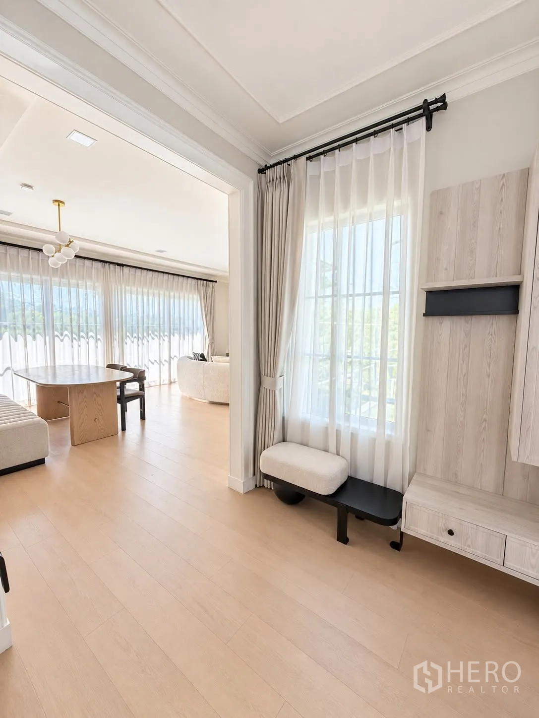 独栋房屋 for rent in Bang Phli, Samut Prakan - 走廊通向起居区，落地窗帘与浅色地面。