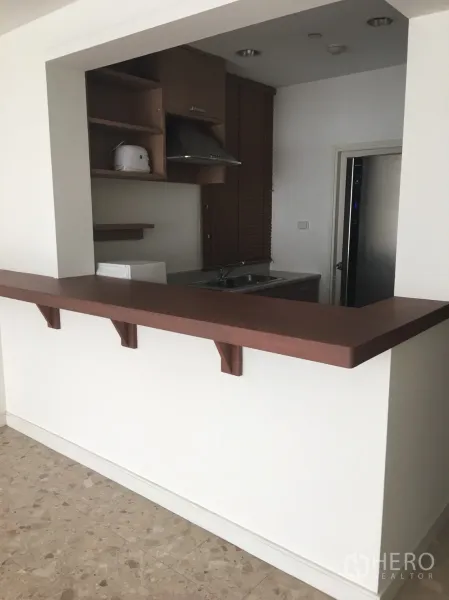 Condominium for rent in Watthana, Bangkok - Open kitchen with breakfast bar, shelves, range hood, sink and microwave.