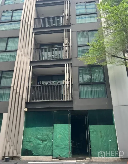 零售空间 出租 - 素坤逸–阿索克区域的现代低层楼宇，一层店铺玻璃门面与上方阳台。