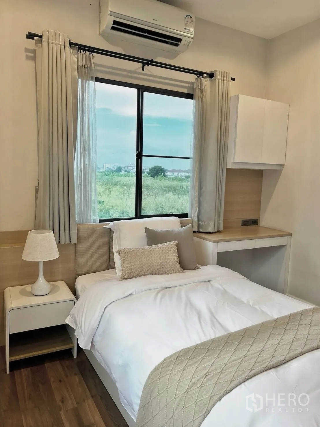 Detached House for rent in Prawet, Bangkok - Bright bedroom with single bed, bedside table, built-in desk, and window with air conditioner.