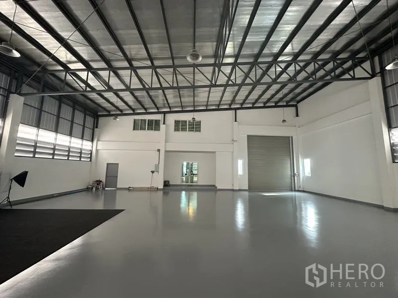 โรงงาน ขายในLam Luk Ka, Pathum Thani - พื้นที่คลังสินค้าพร้อมประตูม้วนขนาดใหญ่ ช่องระบายอากาศ และสเปซไร้เสา