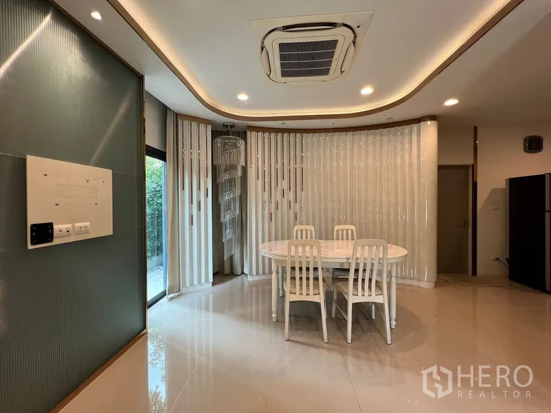 Detached House for rent in Saphan Sung, Bangkok - Dining zone with oval table, cassette air-conditioning and feature lighting.