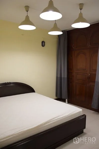 Townhouse for rent in Watthana, Bangkok - Bedroom with bed, pendant lights and built-in wooden wardrobe.