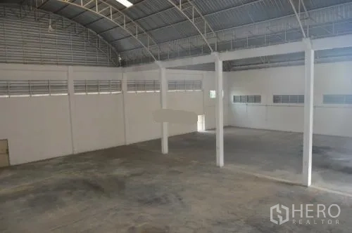 Warehouse for rent in Samut Sakhon - View over the large warehouse floor and steel truss roof from a mezzanine level.