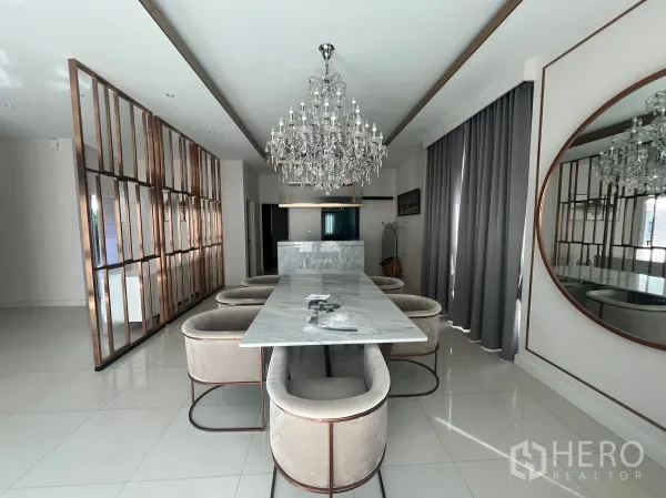 Detached House for rent or sale in Prawet, Bangkok - Elegant dining area featuring a marble table, crystal chandelier and brass room divider.