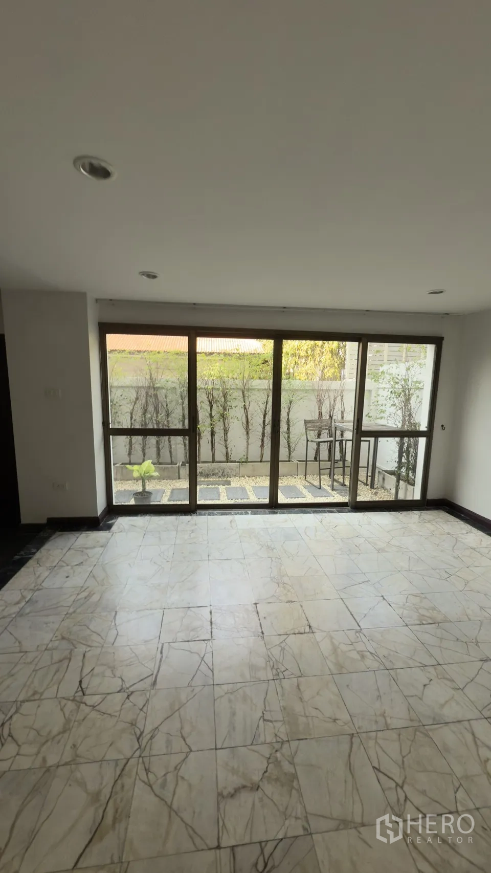 联排别墅 for rent in Watthana, Bangkok - 透过落地推拉门看到的小型私家庭院。