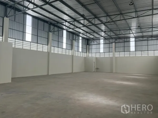 Factory for rent in Bang Phli, Samut Prakan - Spacious warehouse interior with 7–11 m high steel roof, skylights and smooth concrete floor.