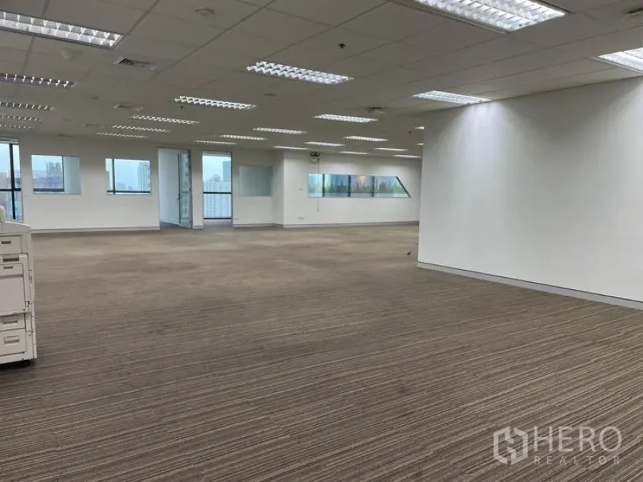 สำนักงาน ให้เช่า - โถงออฟฟิศกว้าง พื้นพรม ไฟเพดานหลายชุด และห้องกั้นกระจก
