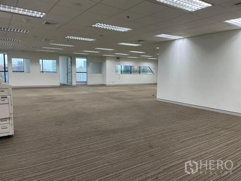 สำนักงาน ให้เช่า - โถงออฟฟิศกว้าง พื้นพรม ไฟเพดานหลายชุด และห้องกั้นกระจก
