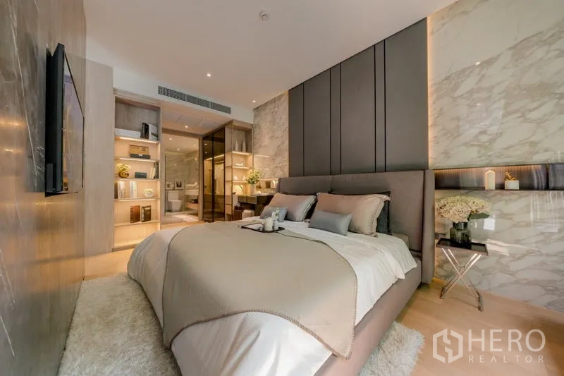 Condominium for rent in Watthana, Bangkok - Master bedroom with upholstered headboard, feature walls, and built-in shelving.