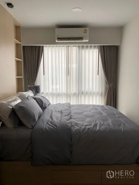 公寓 出租或出售在Yan Nawa, Bangkok - 温馨卧室，双人床、内置书架、空调与遮光窗帘。