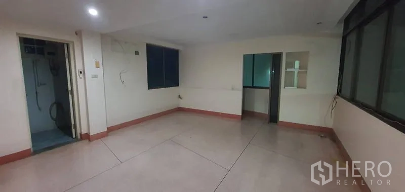 Warehouse for rent in Bang Kho Laem, Bangkok - Open room with bathroom door, multiple windows, and tiled floor.