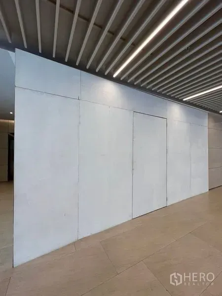Retail Space for rent in Pathum Wan, Bangkok - Closed retail frontage with white panel door beneath linear ceiling lights in a lobby.