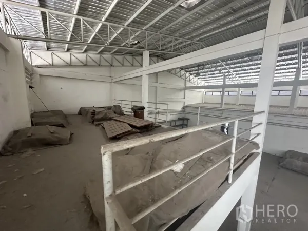 Factory for rent or sale in Prawet, Bangkok - Mezzanine storage platform with metal railing under a metal roof.