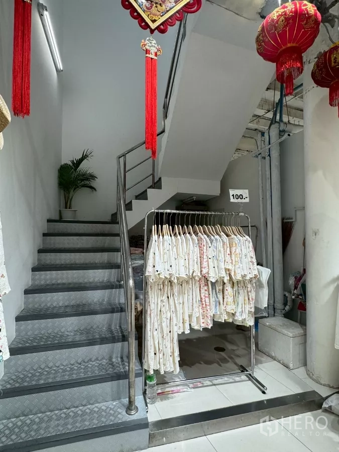 店屋 出租在Samphanthawong, Bangkok - 店内楼梯，旁为服装陈列与灯笼装饰。