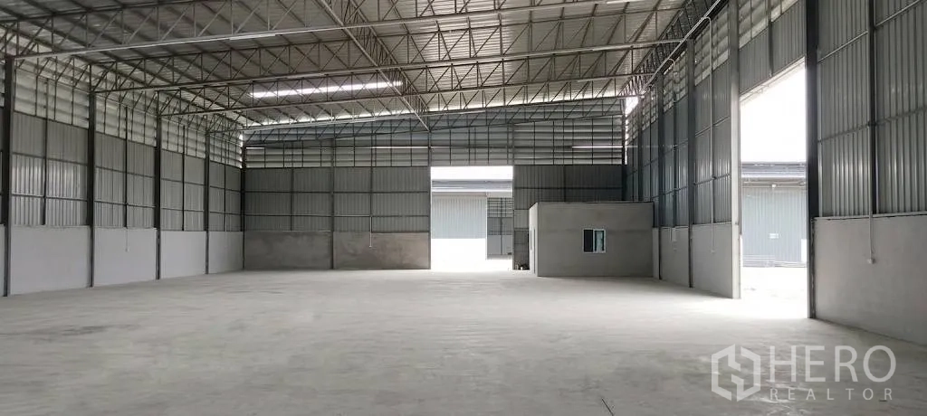 Warehouse for rent in Mueang Samut Sakhon, Samut Sakhon - Open-plan warehouse with steel trusses, smooth concrete floor, and an office unit.