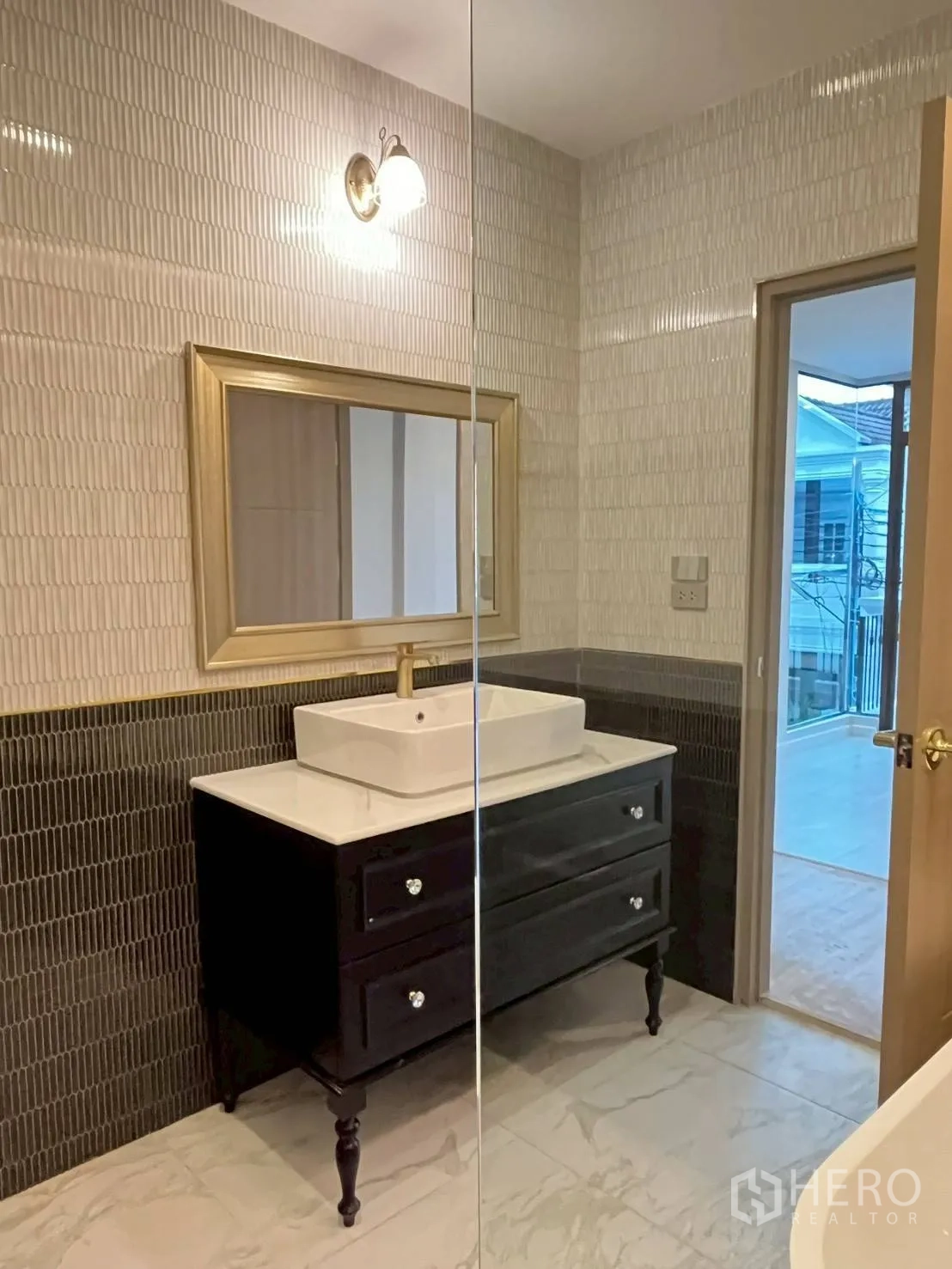 联排别墅 for rent in Khlong Toei, Bangkok - 盥洗区配金色框镜、纹理墙砖与仿石纹地砖。