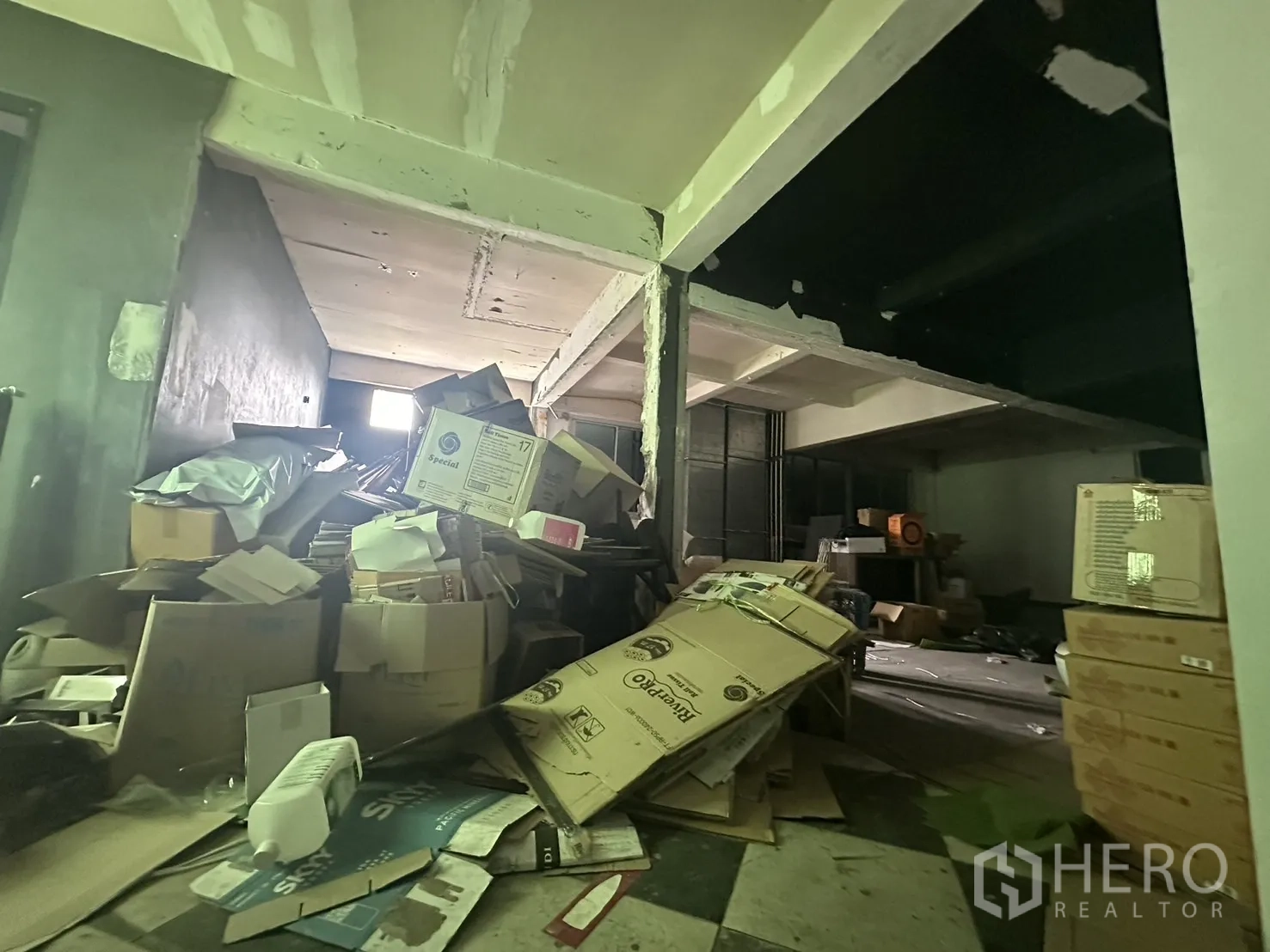 Shophouse for rent in Watthana, Bangkok - Cluttered storage floor with cardboard boxes in an unfinished room.