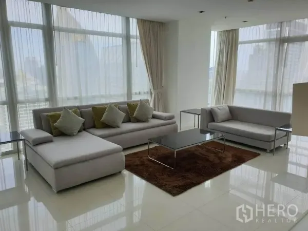 คอนโด ให้เช่าในPathum Wan, Bangkok - ห้องนั่งเล่นสว่างผนังกระจกเต็มบาน โซฟาสีเทา พร้อมวิวสกายไลน์กรุงเทพฯ