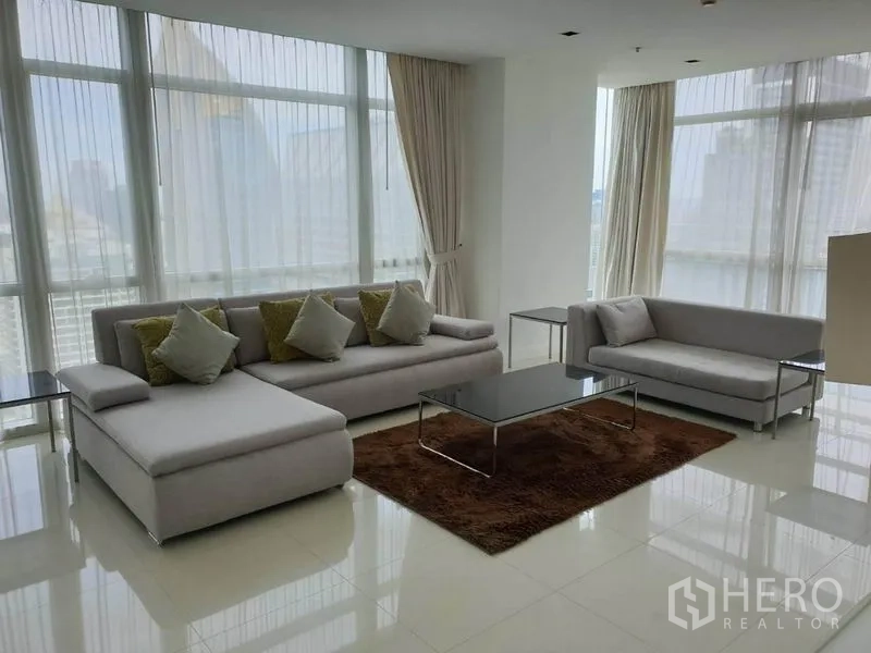 คอนโด ให้เช่าในPathum Wan, Bangkok - ห้องนั่งเล่นสว่างผนังกระจกเต็มบาน โซฟาสีเทา พร้อมวิวสกายไลน์กรุงเทพฯ