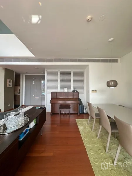 Condominium for rent or sale in Sathon, Bangkok - Open dining zone with upright piano, six chairs, and pendant lighting.