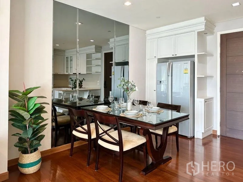 Condominium for rent in Watthana, Bangkok - Dining corner beside a mirrored wall and double-door fridge next to the kitchen.