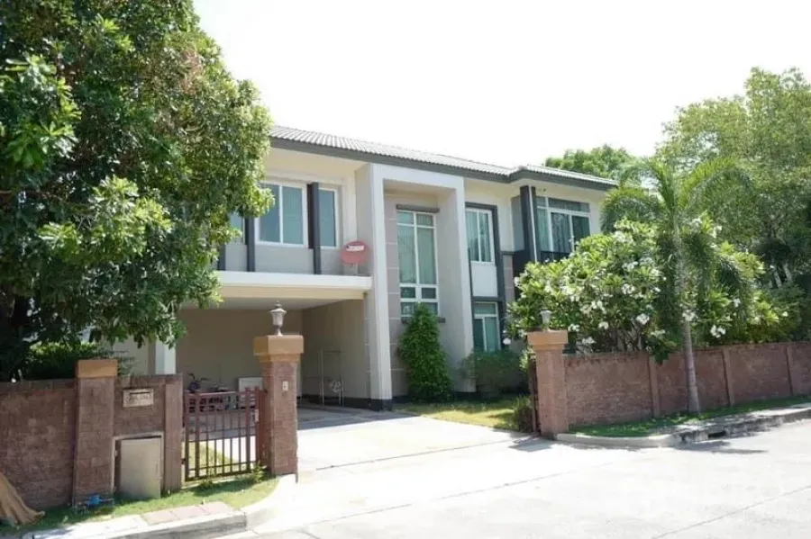 独立式住宅 出售在Pak Kret, Nonthaburi - 两层现代独栋别墅，带院门车道、遮棚车位与成荫绿树。