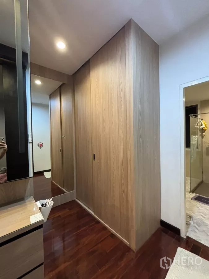独立式住宅 出租在Bang Kapi, Bangkok - 更衣走廊，木质衣柜与梳妆台，旁接浴室。