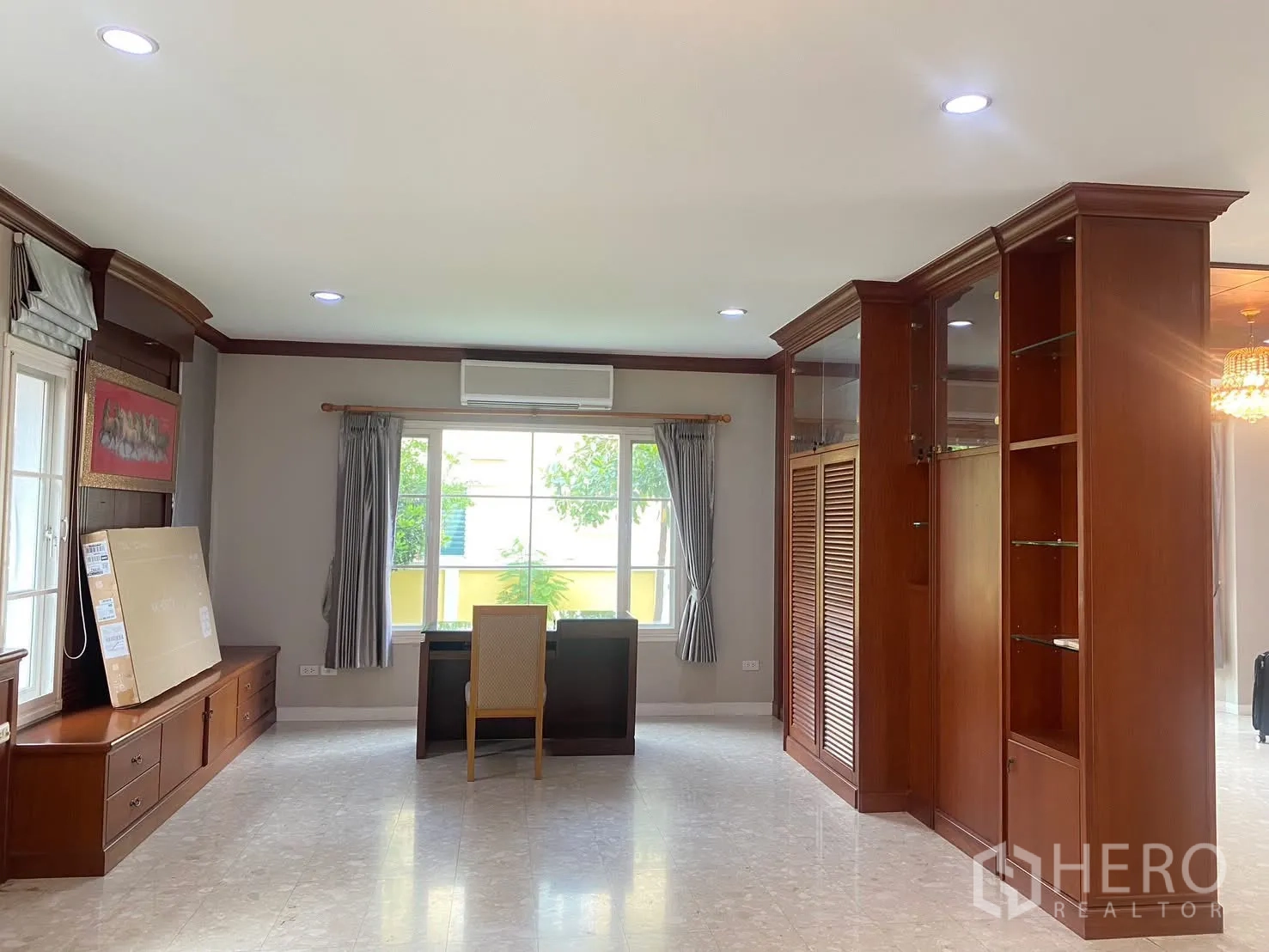 Detached House for rent in Phra Khanong, Bangkok - Multi-purpose room with built-in wooden cabinetry, desk by the window, and air conditioner.