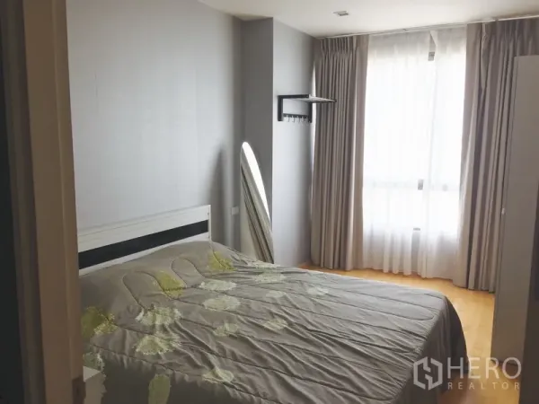 Condominium for rent or sale in Khlong Toei, Bangkok - Second bedroom with double bed, full-height curtains and a standing mirror.