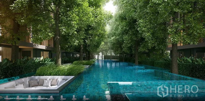 Condominium for rent in Khlong Toei, Bangkok - Long landscaped swimming pool shaded by mature trees with a sunken seating area.