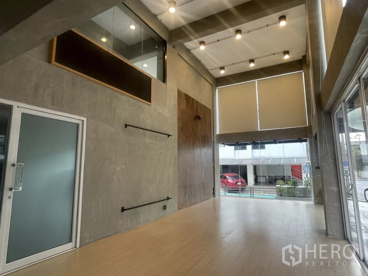带办公室的家 出租在Suan Luang, Bangkok - 双层挑高展示空间，落地窗与射灯照明。