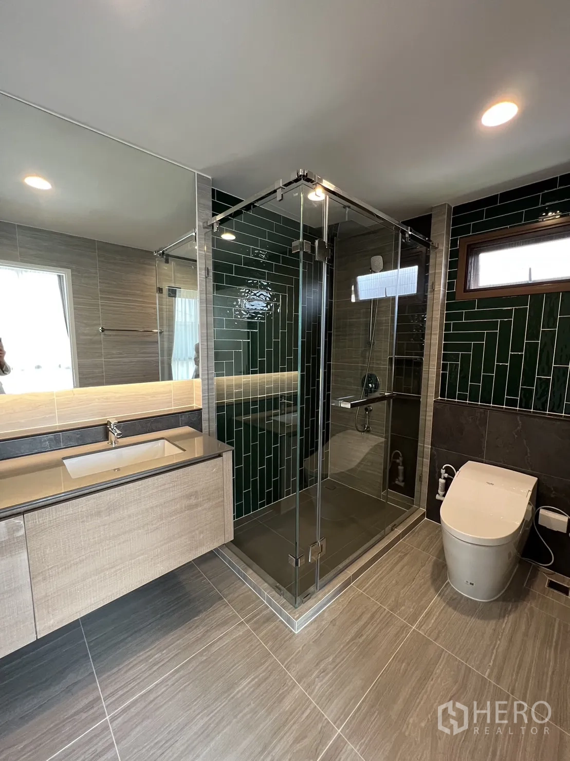 Detached House for rent in Bang Kapi, Bangkok - Master bathroom with glass shower, vanity and dark green wall tiles.