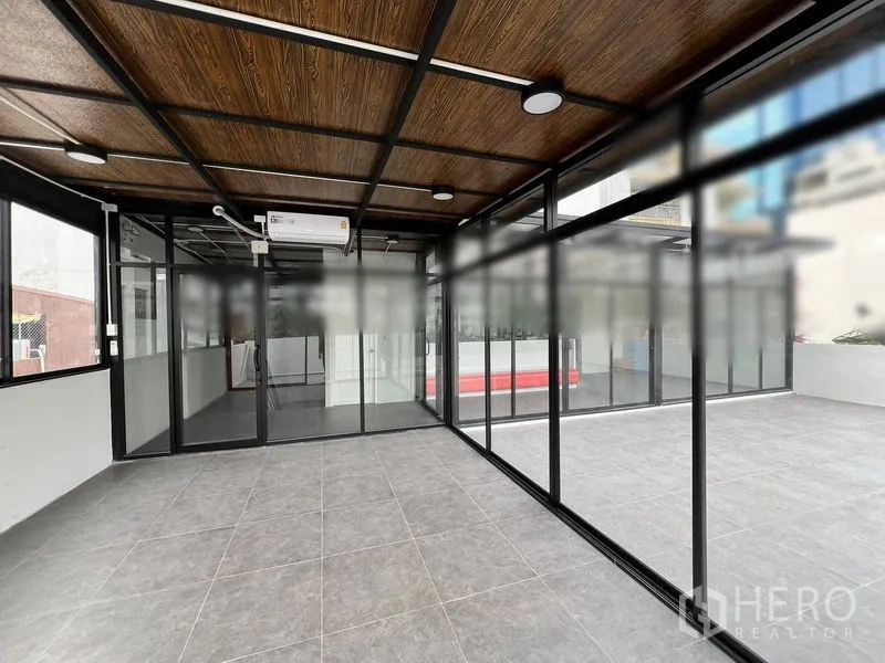 Retail Space for rent in Watthana, Bangkok - Showroom interior with floor-to-ceiling windows looking onto a large tiled terrace.