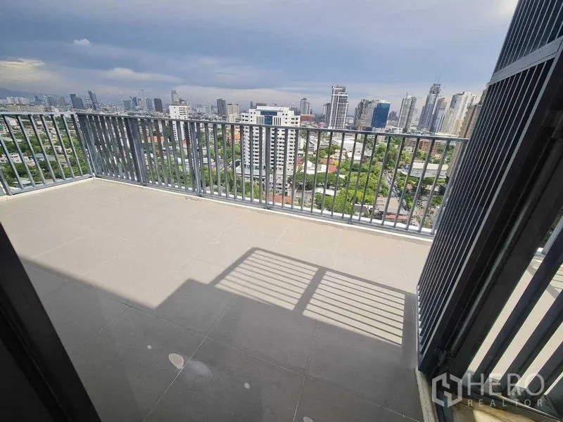 Condominium for sale - Corner terrace with tiled floor and panoramic city view from an Ekkamai condominium.