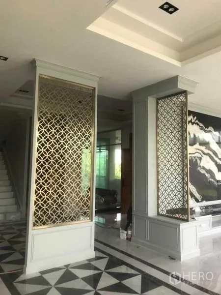 独立式住宅 出售在Mueang Nonthaburi, Nonthaburi - 精致花格隔断，衬托黑色大理石景墙的会客区。
