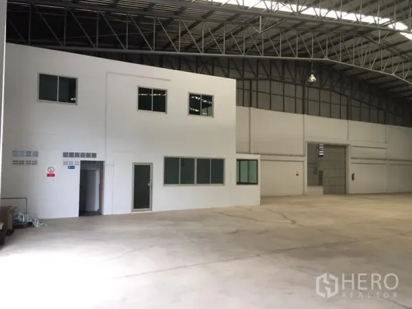 Warehouse for rent in Si Racha, Chon Buri - Two-storey internal office block with glazed windows inside the warehouse.