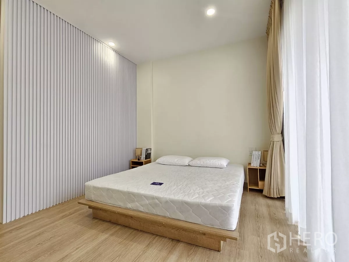 Townhouse for sale in Lat Phrao, Bangkok - Bedroom angle showing ribbed accent wall and natural light.
