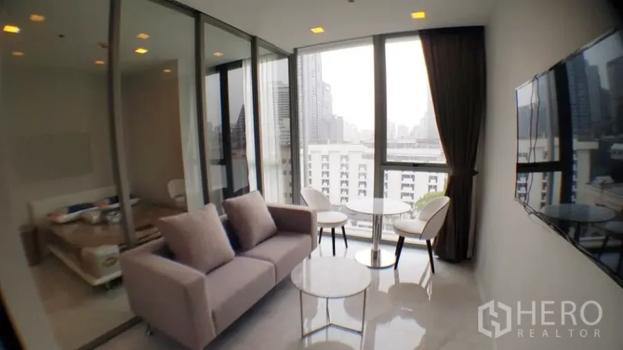 คอนโด ให้เช่าในWatthana, Bangkok - ห้องนั่งเล่นสว่างในคอนโด 1 ห้องนอน มีหน้าต่างเต็มผนัง วิวเมือง ผนังกระจกกั้นห้องนอน และทีวีติดผนัง ในเขตวัฒนา กรุงเทพฯ