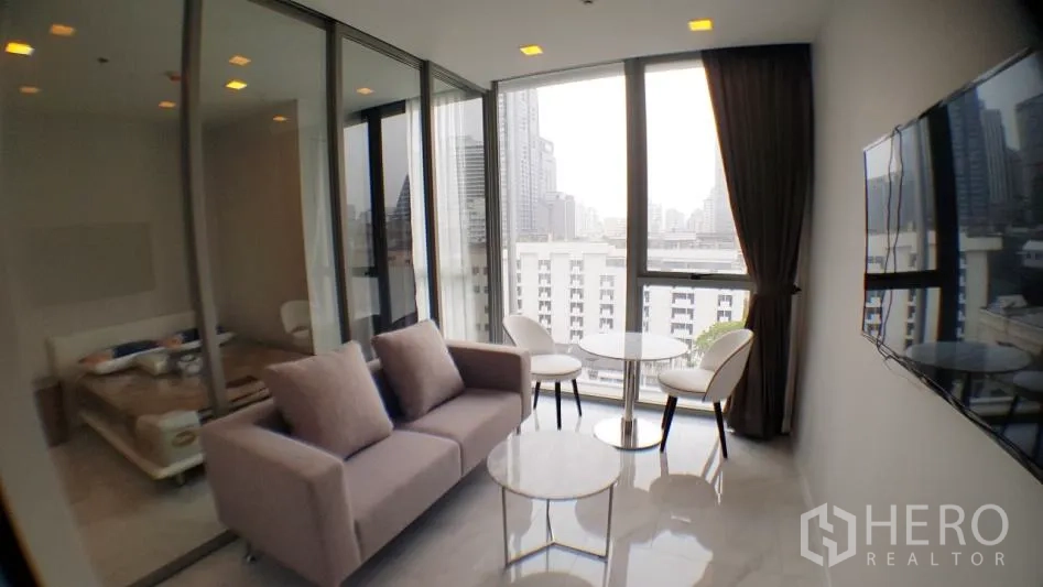 คอนโด ให้เช่าในWatthana, Bangkok - ห้องนั่งเล่นสว่างในคอนโด 1 ห้องนอน มีหน้าต่างเต็มผนัง วิวเมือง ผนังกระจกกั้นห้องนอน และทีวีติดผนัง ในเขตวัฒนา กรุงเทพฯ