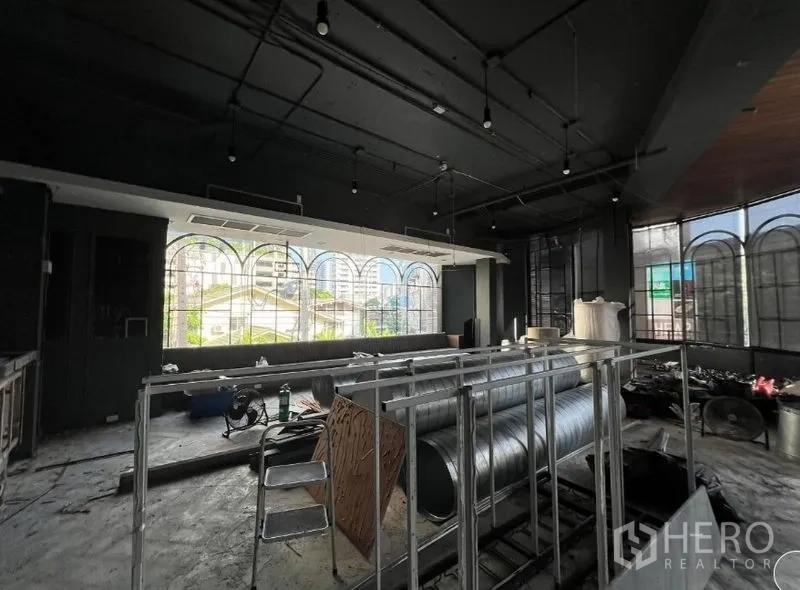 Retail Space for rent - Open-plan room with panoramic arched windows, city outlook and industrial-style ceiling.