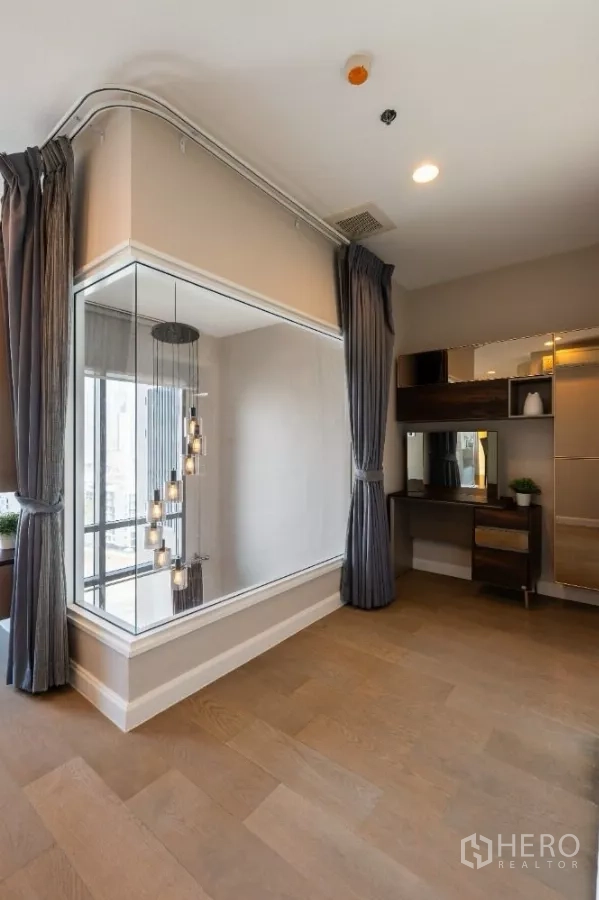 Condominium for rent or sale in Khlong Toei, Bangkok - Mezzanine corner with glass wall and cascading pendant lights over the living area.