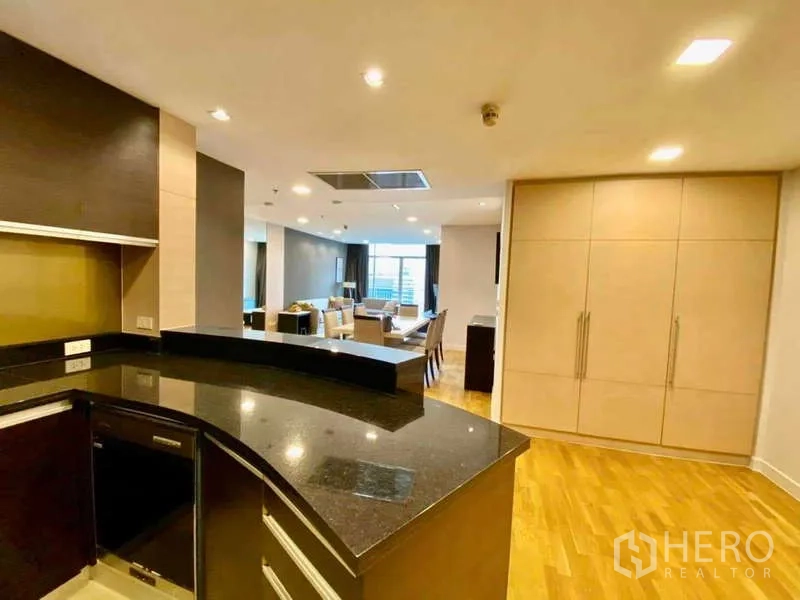 Condominium for rent or sale in Sathon, Bangkok - Kitchen countertop view toward the spacious living and dining area with built-in storage.