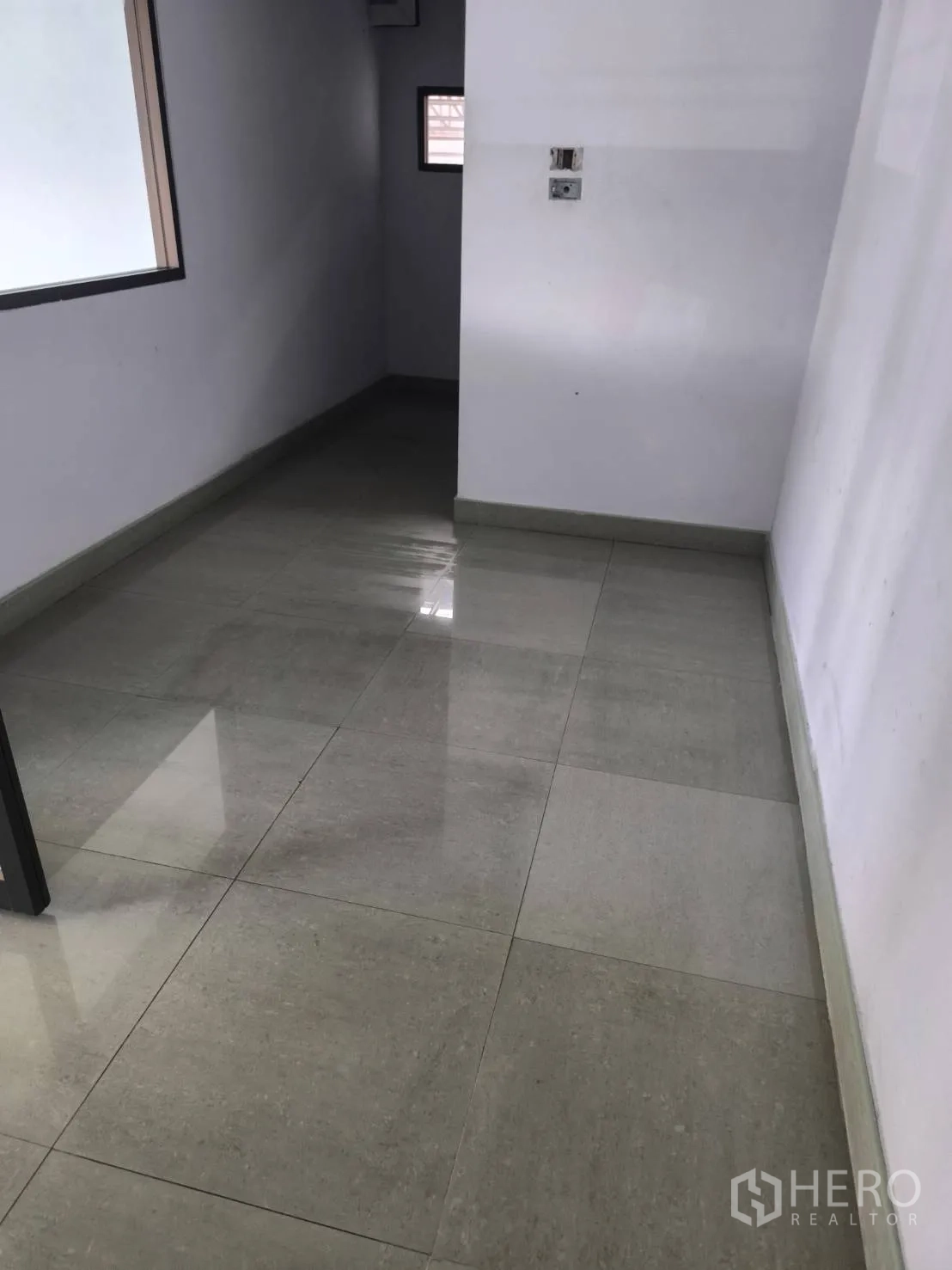 Factory for sale in Khlong Luang, Pathum Thani - Narrow tiled corridor with a small window.