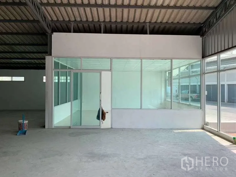 Warehouse for rent in Mueang Pathum Thani, Pathum Thani - Glass-enclosed office room with sliding door inside the warehouse facing the loading area.